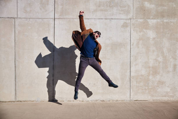 istock Victory concept. Joyful man jumping against concrete wall celebrating success 1473138405