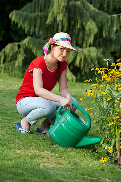 Jeune Jardinier femme arroser les plantes - Photo