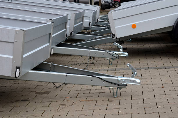 trailer behind a car in the parking lot at the rental shop. just harness to the ball of the towing device. homologation and technical inspections. metal side panels, locked chain, drawbar, homologation , hitch, drawbar remolque detrás de un automóvil en el estacionamiento de la tienda de alquiler. simplemente aproveche la bola del dispositivo de remolque. homologación e inspecciones técnicas. paneles laterales metálicos, cadena bloqueada, barra de tiro