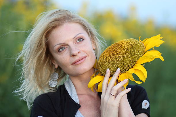 Beauty woman and sunflowers on field stock photo