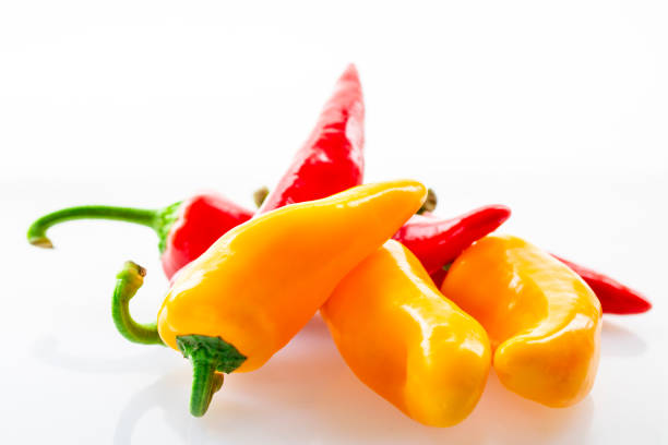 Red and yellow fresh bell peppers on a white background
