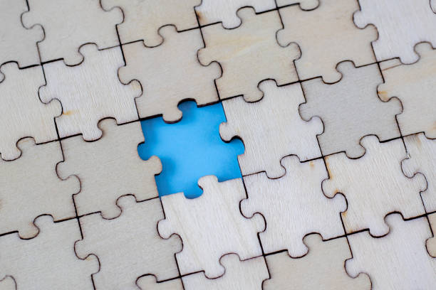 istock Assembled blank wooden puzzles with emphasis on the missing puzzle. 1473144369