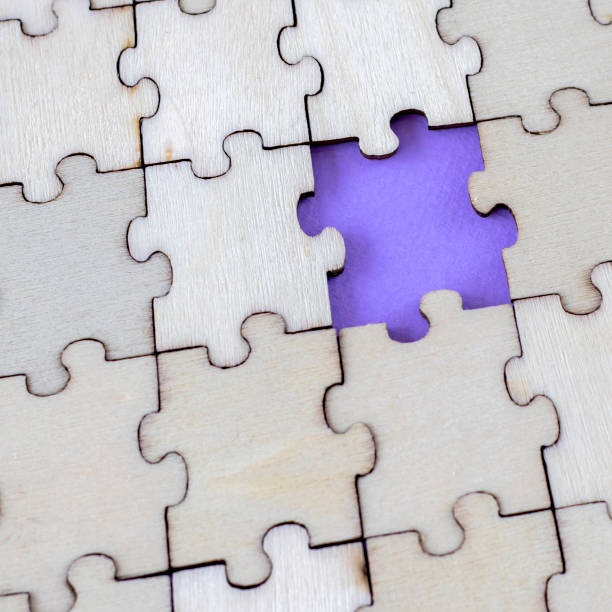 Close-up of the assembled empty wooden puzzles with a missing puzzle. Highlighted purple space for writing or text.