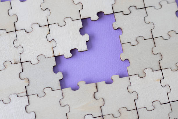 istock Missing heart-shaped puzzles. A background of puzzles with a light purple empty space. 1473144398