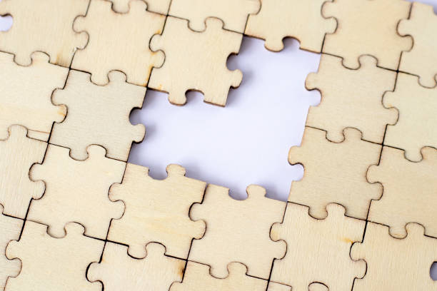 istock Missing heart-shaped puzzles. A background of puzzles with a white empty space. 1473144399