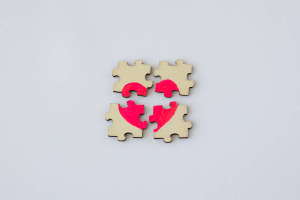 istock Broken puzzle with a painted pink heart on a white background 1473144423