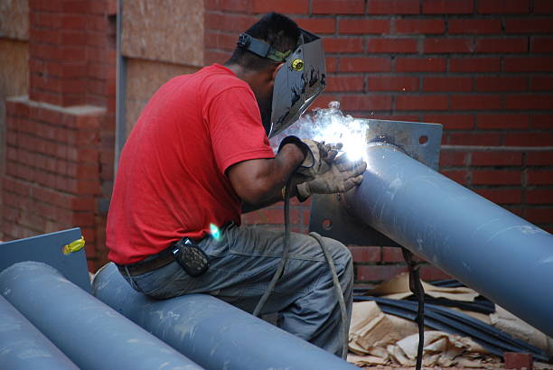 Man welding long pipe stock photo