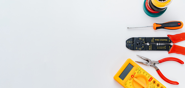 Stripper, Pliers, Multimeter, insulating tape and Screwdriver on a white background. Pliers for removing insulation and crimping wires. concept of working tools for an electrician.