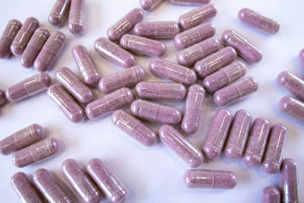 istock Pink capsules with additives on a white background. Pills and medicines. Tart cherry additives, vitamins, minerals, plant extracts and other beneficial substances 1473145251