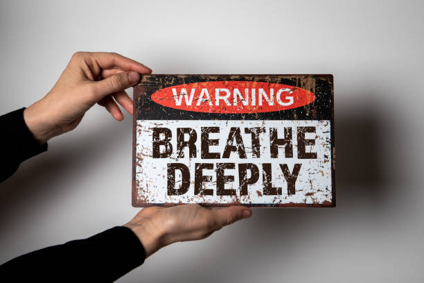 istock Breathe Deeply. Warning sign with text on a white background in a woman's hand 1473145930
