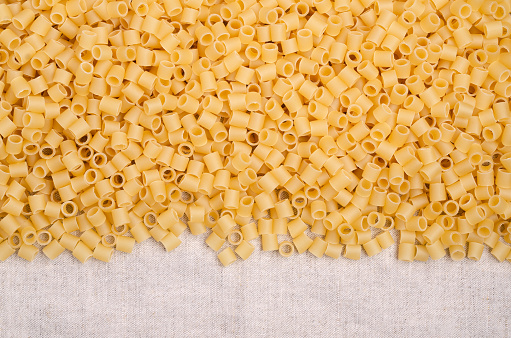 Traditional Italian dry pasta on a light textile background. Copy space. Top view.