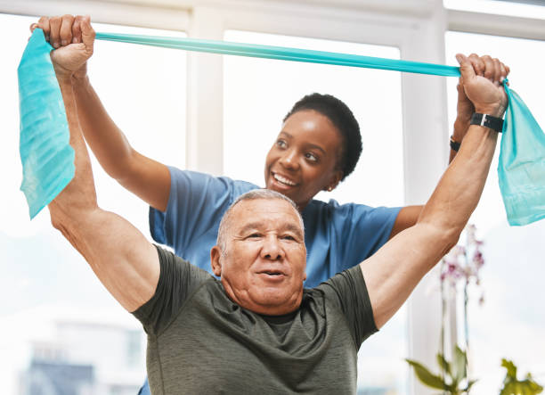 Physiotherapy help, stretching band and doctor with senior man in physical therapy, rehabilitation or healthcare support. Black woman chiropractor or physiotherapist consulting elderly patient Physiotherapy help, stretching band and doctor with senior man for physical therapy, rehabilitation and healthcare support. Black woman chiropractor or physiotherapy doctor consulting elderly patient physical therapist stock pictures, royalty-free photos & images