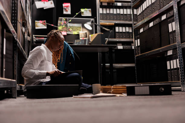 istock Lawyer preparing for case, reading detective report on floor 1473148602