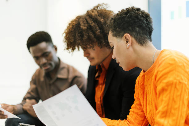 istock Three multiracial young adults sit, discuss, and study the project together 1473150386