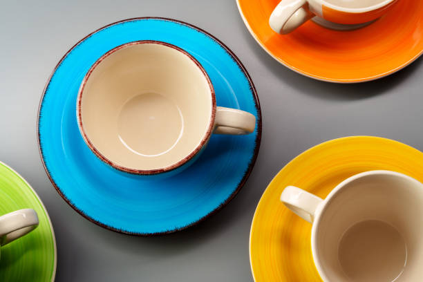 Colorful clay ceramic cups on gray background close up