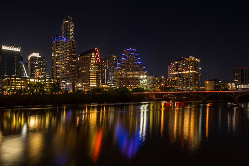 Austin, Texas, USA - June 19, 2021: Beautiful illuminated cityscape at night reflecting in Colorado river (Lady Bird Lake)