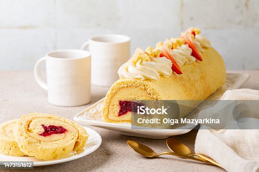 istock Swiss or jelly roll cake, cream roll, roulade or Swiss log is a type of rolled sponge cake filled with custard cream and berry jelly, and decorated with whipped cream cheese and strawberries. Homemade. 1473151612