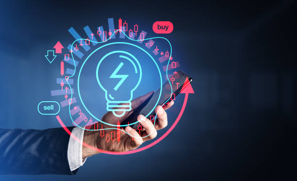 istock Businessman hand with smartphone, lightbulb hologram with candlesticks 1473152137
