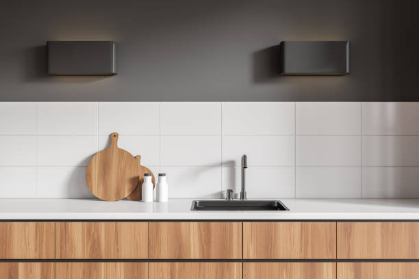 Stylish kitchen interior with cooking area, sink and kitchenware