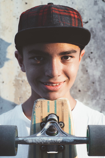 Boy skater posing with skateboard.