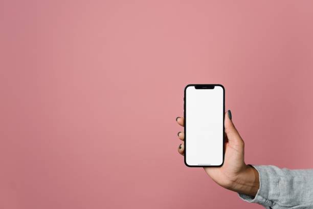 istock male hand holds a smartphone with a white screen on a pink background 1473155866
