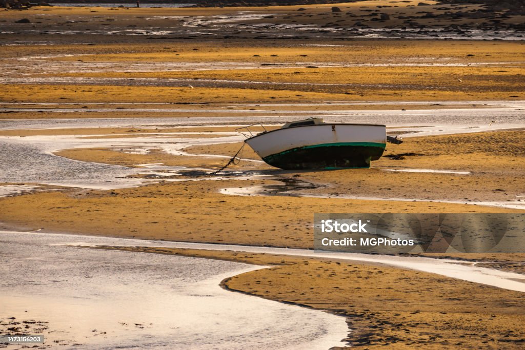 Stranding A small fishing boat stranded on a sandbank because of low tide. Colorful seascape. Stranded Stock Photo