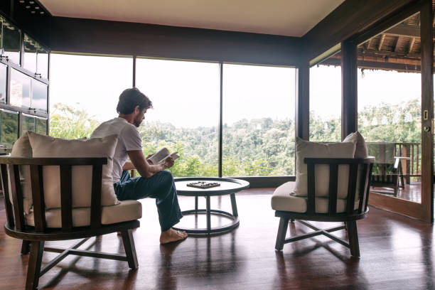 istock Man reading book in a hotel room 1473162163