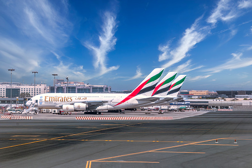 Morning in Dubai DXB airport. Airbus A380 aircraft of Emirates air company is being towed to the runway before a takeoff.