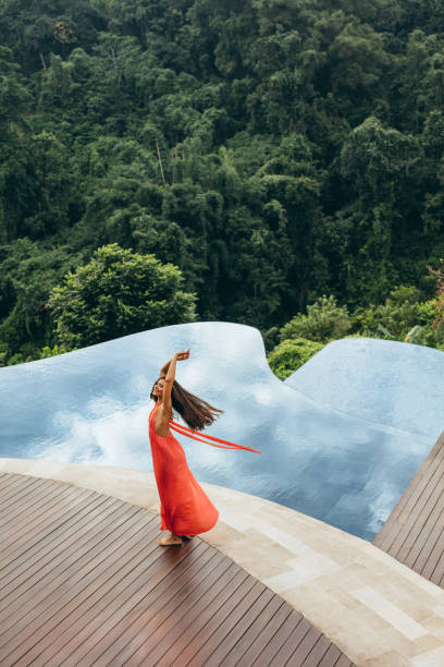 istock Young woman at poolside looking happy 1473162471