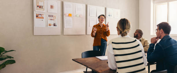 istock Mature designer pitching her idea to her team in a creative office 1473163119