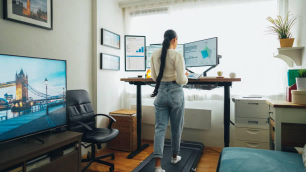 istock Woman at home office is walking on under desk treadmill 1473164556