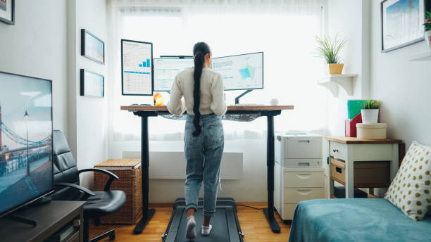 istock Woman at home office is walking on under desk treadmill 1473164621