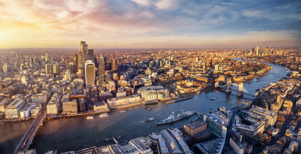 Panoramic sunset view over the skyline of the City of London Panoramic sunset view over the skyline of the City of London, England, down the River Thames with Tower Bridge and Canary Wharf district central london skyline stock pictures, royalty-free photos & images
