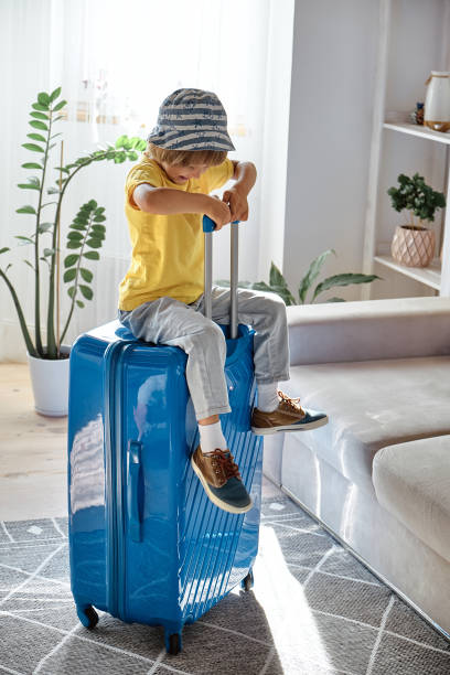 istock A child sitting on a suitcase have fun and laughs, waiting for a trip on vacation 1473167305