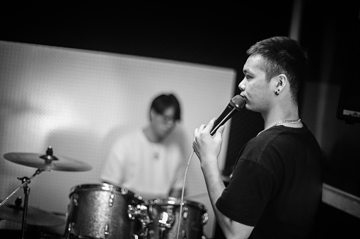 Young singer and drummer practicing their track fort the public performance