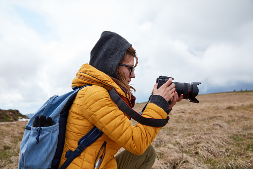 Young woman photographer enjoying in nature.