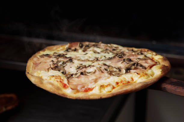 istock Cook pulls out the finished pizza from the oven in the kitchen 1473168350