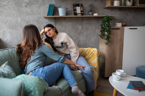 istock Two sisters talking in the living room 1473171362