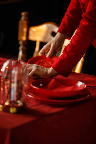 Young woman adding a red colored accents on the table for a Valentine's day celebration