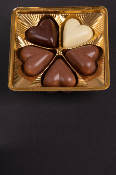 photo of chocolate hearts in a package on a black background