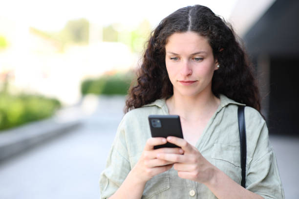 istock Woman using phone and walking in the street 1473178073