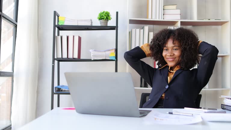 Businesswoman working with laptop on desk in office at home and relaxing after work.