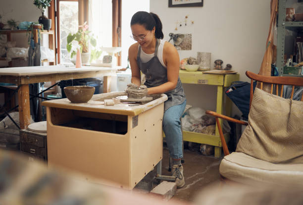 istock Clay, creative or woman in pottery workshop working on a cup sculpture or mug mold in small business. Focus, artistic girl or happy Japanese designer manufacturing handicraft products as entrepreneur 1473188452