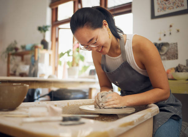 istock Clay, happy or creative woman in workshop working on an artistic cup or mug mold in small business. Pottery project, Asian girl or Japanese designer manufacturing handicraft products as entrepreneur 1473189143
