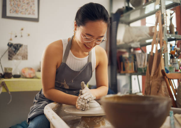 istock Clay, sculpture or creative woman in workshop working on an artistic cup or mug mold in small business. Smile, Asian girl or happy Japanese worker manufacturing pottery products as entrepreneur 1473189147