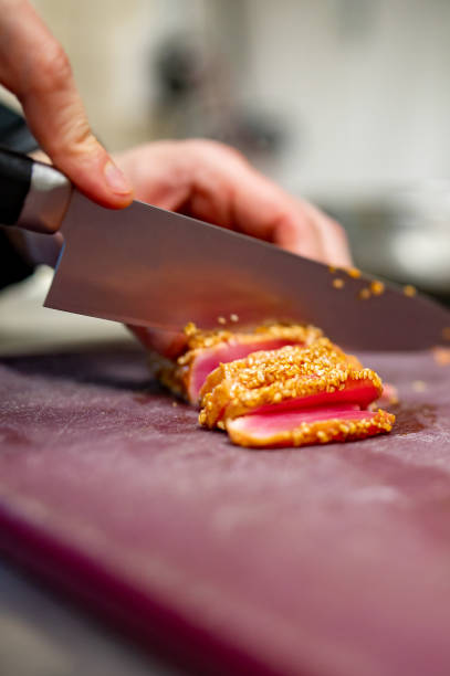 istock chef hands cut tuna into slices on a board in a restaurant kitchen 1473190712