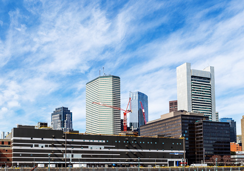 View across the Fort Point Channel of the Fort Point Pier and downtown Boston buildings. A large United States Postal Service facility is in the foreground.