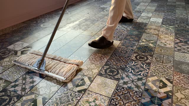 Man mopping the tiled ceramic floor