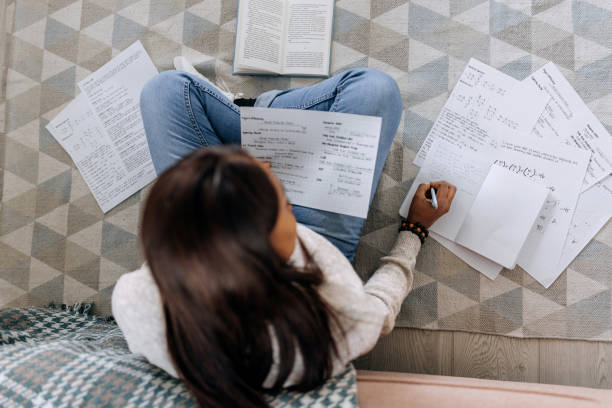 istock Young beautiful woman studying from her apartment while sitting on the floor 1473193127