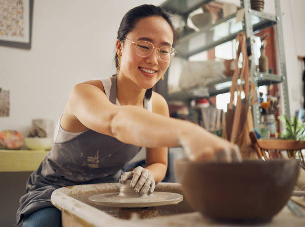 istock Happy, pottery or woman in designer workshop working on cup sculpture or mug mold in small business. Smile, artistic girl or creative Japanese worker busy with handicraft products as entrepreneur 1473193935